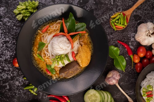 Preview: Chicken curry in a black cup with rice noodles.