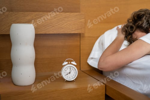 Preview: Woman sleeping soundly ignoring a loud alarm clock