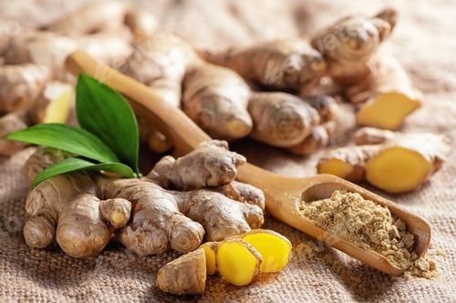 Preview: Fresh chopped ginger root and ground ginger powder in wooden spoon