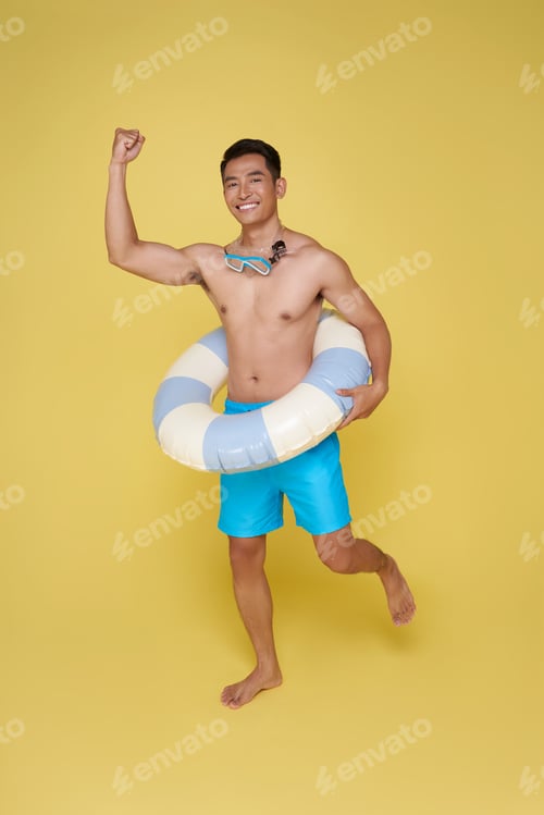 Preview: Full body young tourist asian man hold inflatable ring jumping happy summer vacation