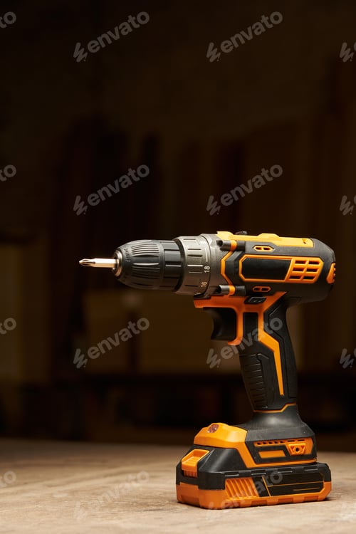 Preview: Black and Orange Power Drill on Wooden Surface