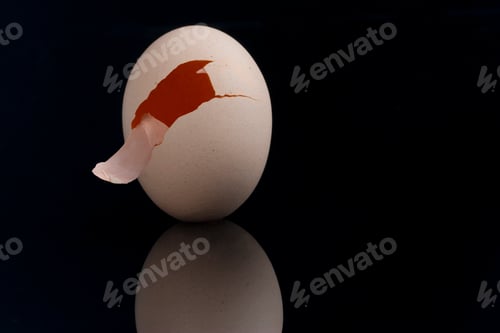 Preview: Closeup shot of a cracked egg isolated on a black background