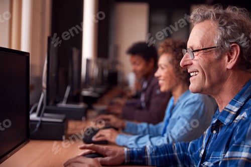 Preview: Group Of Mature Adult Students In Class Working At Computers In College Library