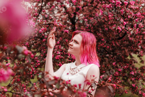 Preview: Young girl with pink hair in Apple orchard.