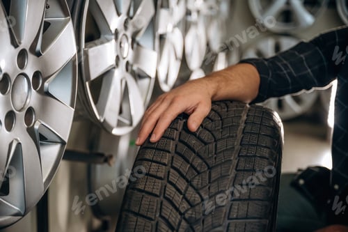 Preview: Bunch of tires, wheels. Man worker is maintenance station