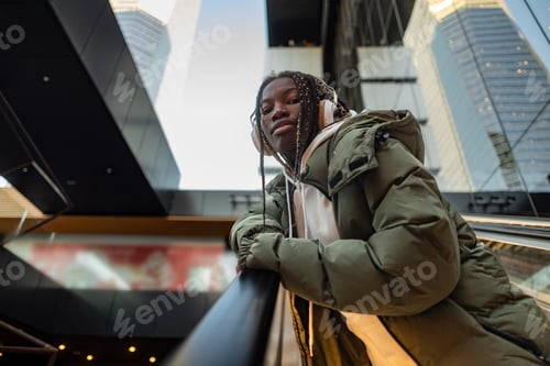 Preview: A young black teenage girl with dreadlocks on an outdoor escalator shopping mall