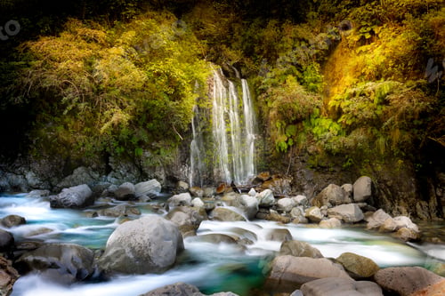 Preview: Breathtaking view of waterfall flowing through golden autumn tree in Otira Gorge, long exposure