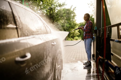 Preview: Woman washes off foam from the car, hand auto wash