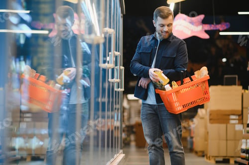 Preview: Handsome young man choosing food in the supermarket