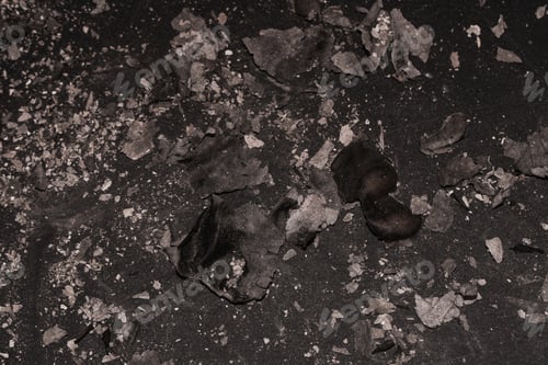 Preview: Scattered burnt ashes and debris on a dark background