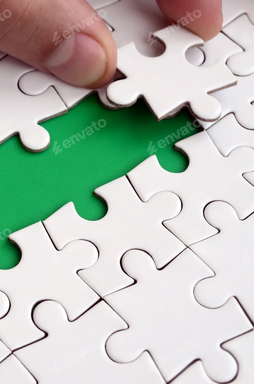 Preview: The human hand paves the way to the surface of the jigsaw puzzle, forming a green space.
