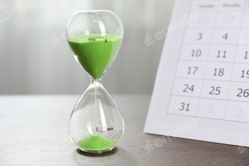 Preview: Deadline. Hourglass with flowing sand and calendar on wooden table indoors, closeup