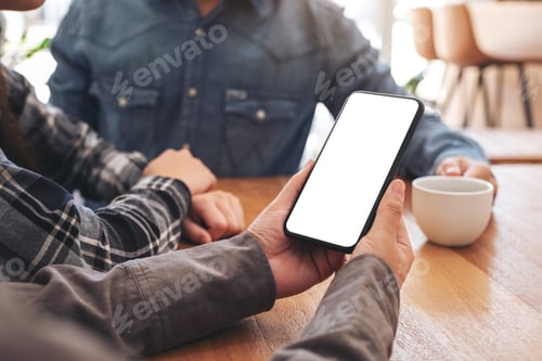 Preview: Woman using and looking at mockup mobile phone with friends in office