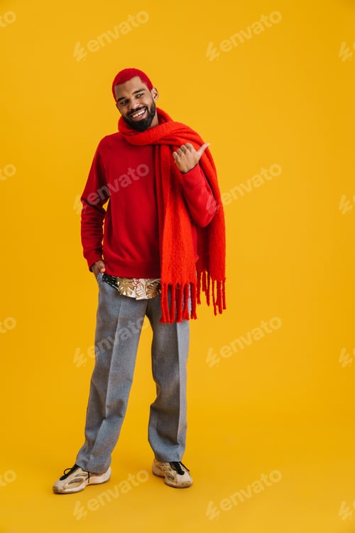 Preview: Happy african american guy smiling and pointing finger aside