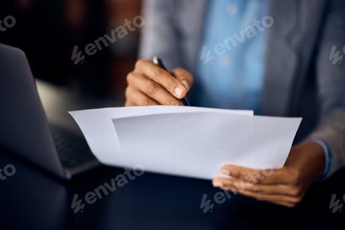 Preview: Close-up of a businesswoman, holding documents, signing, and working over the laptop.