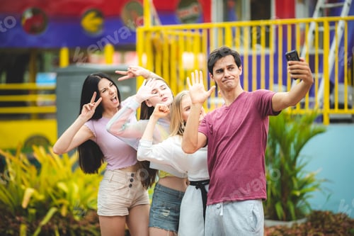 Preview: Group of happy best friends laughing and taking selfie photo at amusement park
