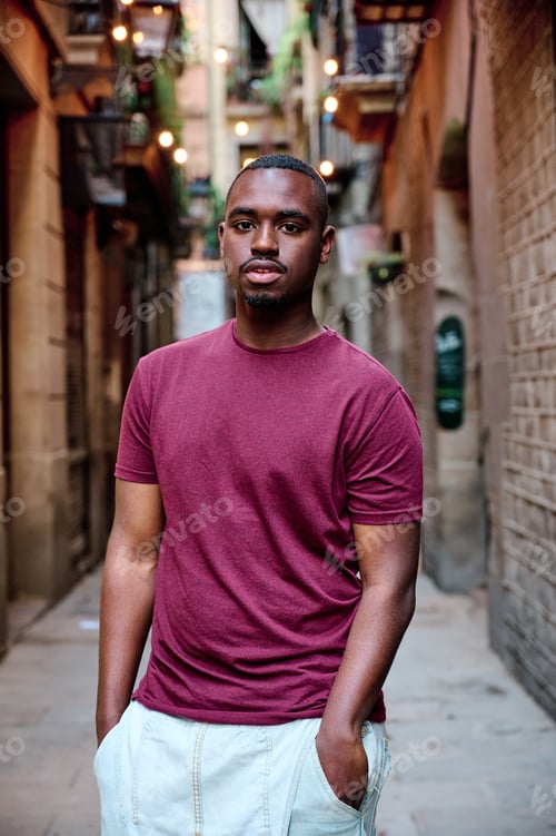Preview: portrait of young black man looking directly to camera in outdoor location