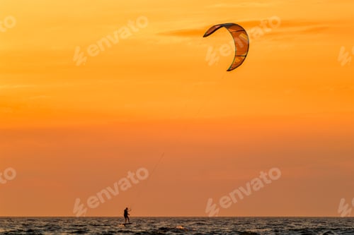 Preview: Kiteboarding kitesurfing kiteboarder kitesurfer kites silhouette in the ocean on sunset