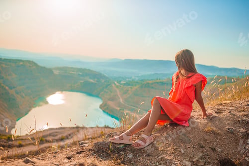 Preview: Little girl near the lake at the day time with amazing nature on background