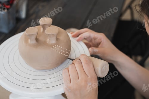 Preview: Woman decorating handmade pottery vase close-up