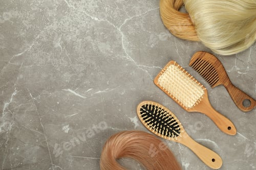 Preview: Female hair and hairbrushes on gray textured background