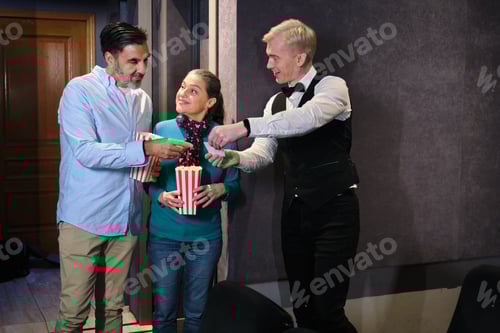 Preview: Usher checking tickets of couple eating popcorn at movie theater