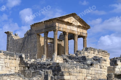 Preview: Capitol at the Roman ruins in Dougga, Tunisia, North Africa against a blue cloudy sky