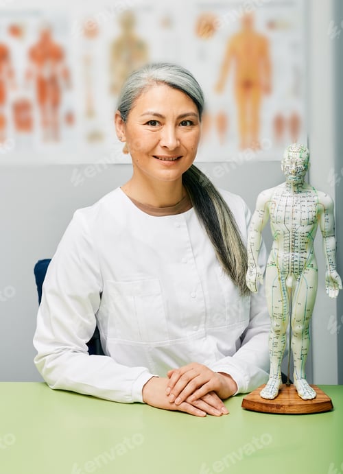 Preview: Mature woman acupuncturist, doctor of traditional Chinese medicine at her medical workplace