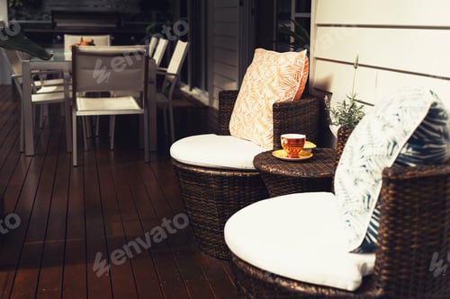 Preview: Veranda of the tropical house with straw chairs and table and cup of coffee or tea on it