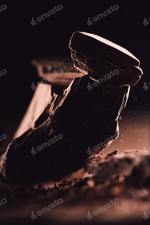 Preview: close up shot of arranged pieces of dark chocolate on black background