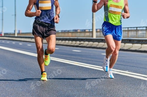 Two men running marathon on a city street