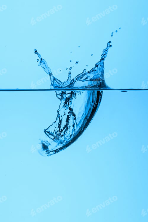 Preview: ice cube in water with splash, isolated on blue
