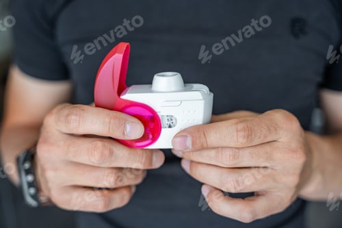 Preview: Close up view of man using medicine dry powder inhaler for treatment asthma or COPD diseases