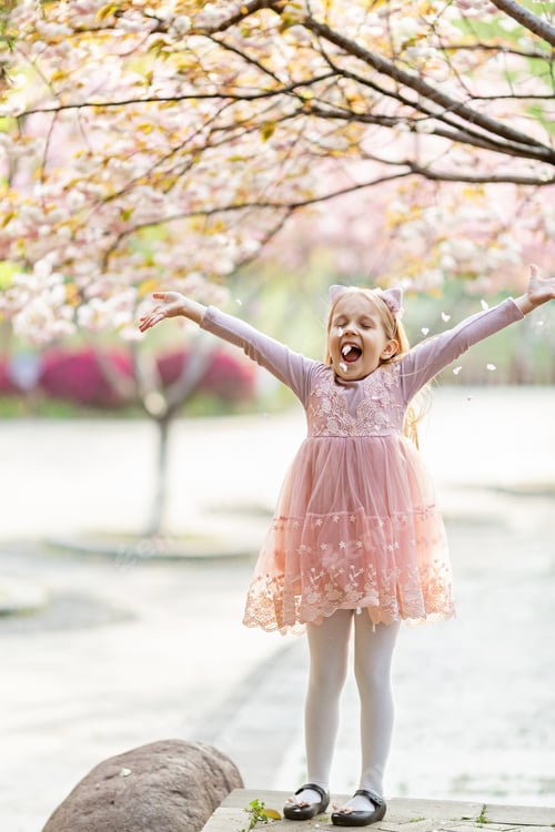 Preview: Portrait of beautiful girl with blooming flowers. Adorable little girl with sakura petals
