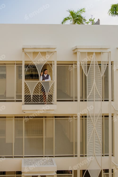 Preview: Asian women at the balcony of an art deco luxury hotel architecture from the 80s