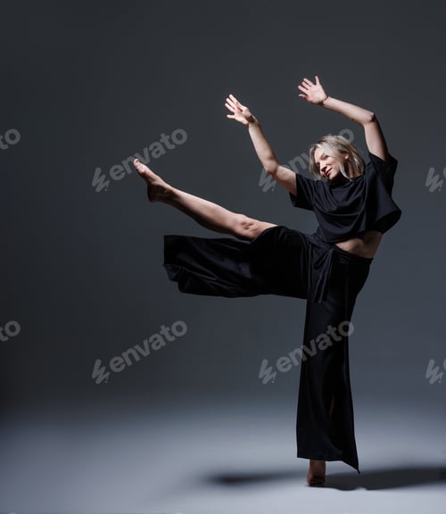 Preview: Dancer in black outfit performs dynamic pose with raised leg and arms extended forward