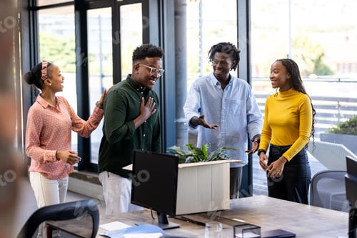 Preview: Diverse team in office celebrating success with smiles and positive energy