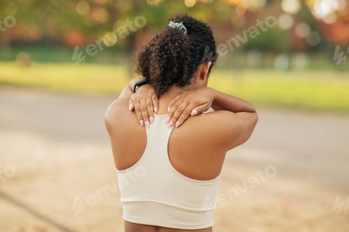 Preview: Woman in Sports Bra Stretching Neck Outdoors