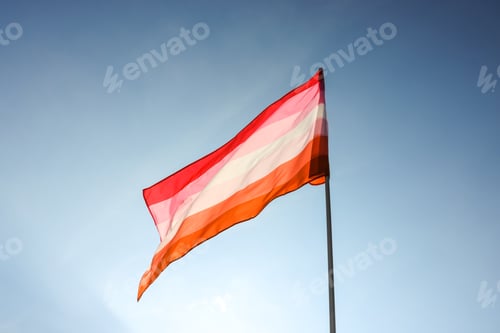 Preview: Bright lesbian flag fluttering against blue sky
