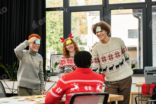 Preview: Young coworkers joyfully celebrate Christmas together in their festive office environment