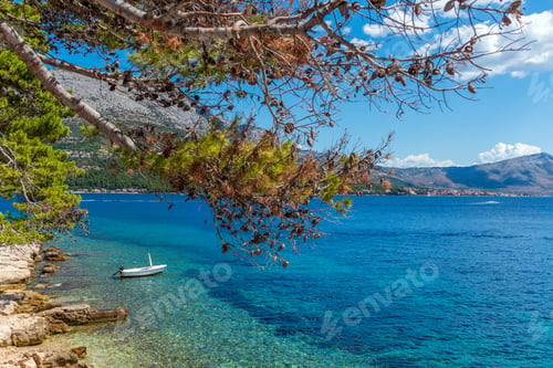 Preview: Small boat moored by rocky beach in idyllic old Korcula town on Korcula island, Croatia