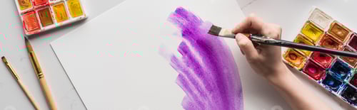 Preview: cropped view of artist drawing purple watercolor brushstrokes on white paper on marble white