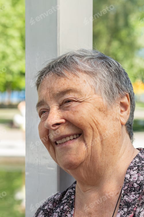 Preview: beautiful senior woman chatting with friends, laughing outdoors, enjoying on walk outdoors in summer