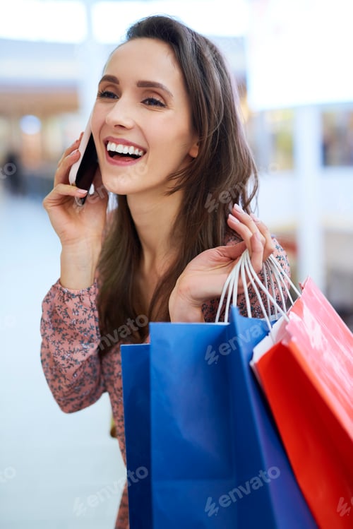 Preview: Smiling Woman Chatting While Shopping at the Mall