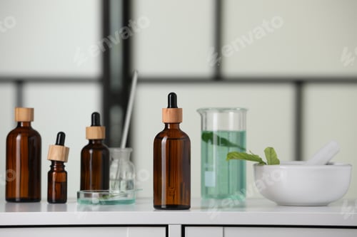 Preview: Bottles and glass tubes with leaves on white lab drawer indoors