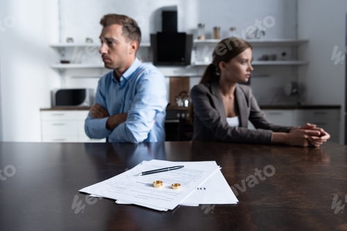 Preview: selective focus of couple sitting at table with divorce documents