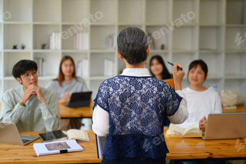 Visualização: Vista traseira do professor sênior conversando com os alunos durante a palestra na sala de aula