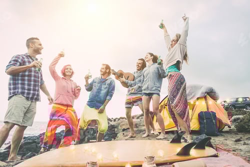 Preview: Happy friends dancing and having fun making a beach party in the campsite