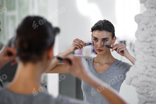Preview: Woman Using Facial Massager In Front Of Mirror
