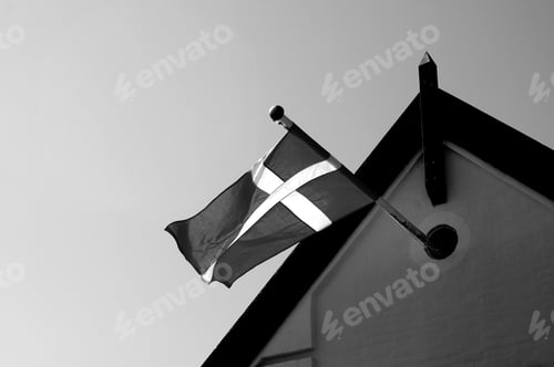 Preview: Grayscale shot of the flag of Finland on the roof of the building